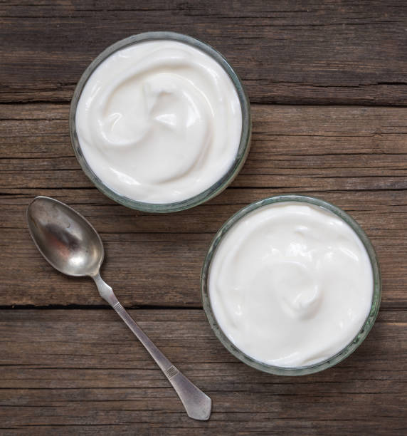 istock White yogurt in glass bowl on old wooden desk with old rustic spoon. 1165166351