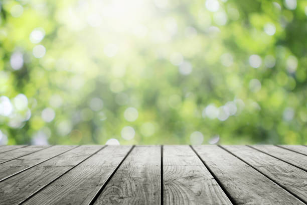 istock Blurred abstract green bokeh and wooden table background. 1165167679