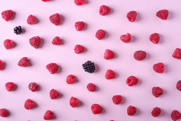 istock Raspberry sweet organic juicy berries with two blackberry, pattern, texture, on pink paper background, flat lay 1165168171