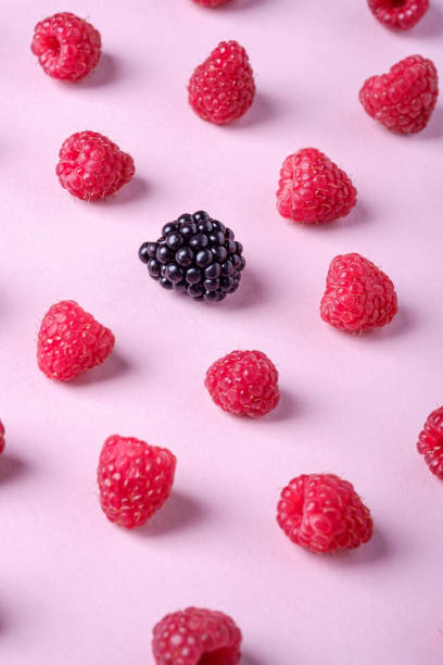 istock Raspberry sweet organic juicy berries with single blackberry, pattern, texture, on pink paper background, macro 1165168223