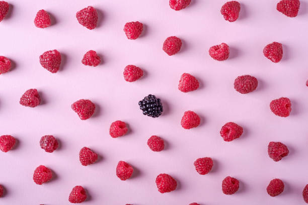 istock Raspberry sweet organic juicy berries with single blackberry, pattern, texture, on pink paper background, flat lay 1165168227