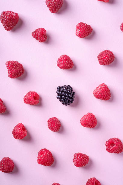 istock Raspberry sweet organic juicy berries with single blackberry, pattern, texture, on pink paper background, flat lay 1165168229