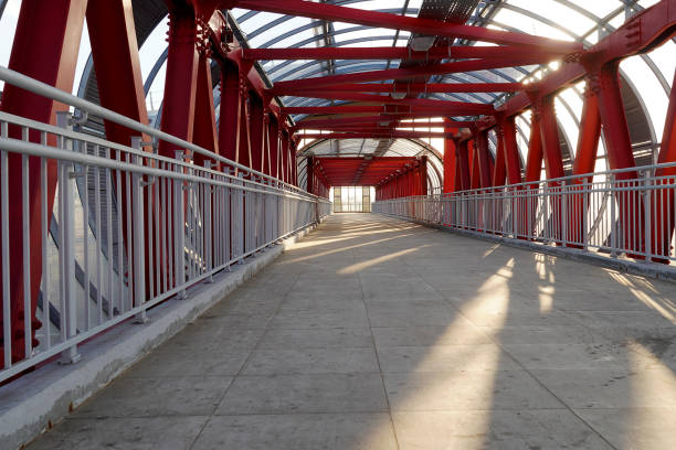 istock Indoor overhead pedestrian crossing with iron construction and glass ceiling. Red iron beams with tiled floor in the tunnel. 1165170439