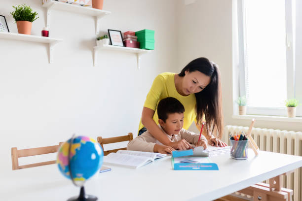 istock Mother Helping Her Little Son With Homework 1165173244