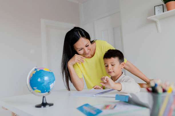 istock Mother Helping Her Little Son With Homework 1165173343