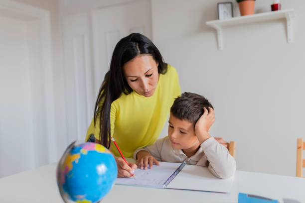 istock Mother Helping Her Little Son With Homework 1165173880
