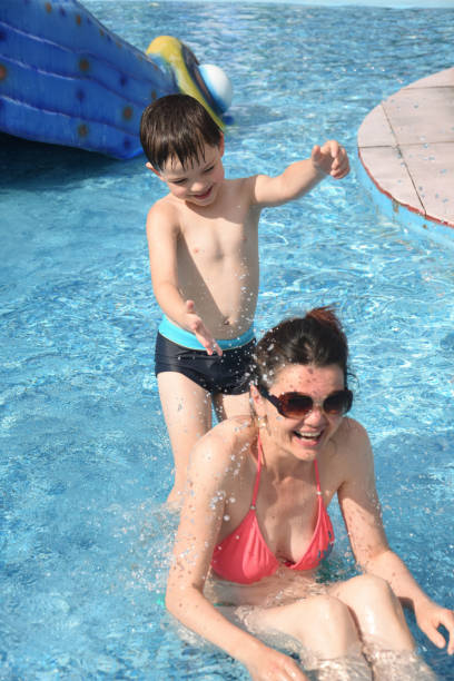 istock 40 Years old Mom play with son in a pool 1165174084
