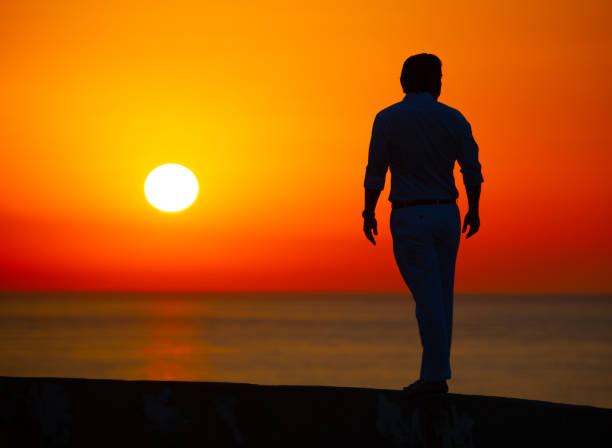 istock Man enjoying colorful sunset or sunrise 1165174109
