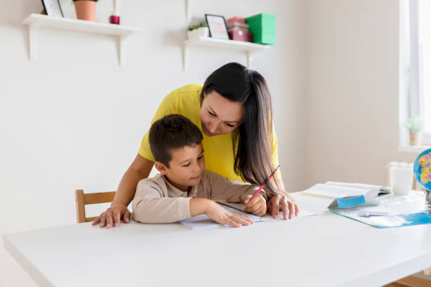 istock Mother Helping Her Little Son With Homework 1165174315