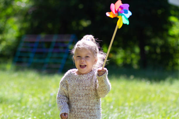 istock Child with Pinwheel in the summer park looking at camera 1165174677