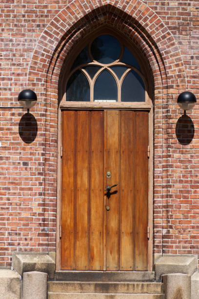 istock Old brown wooden door with doorhandle and red bricks 1165175444