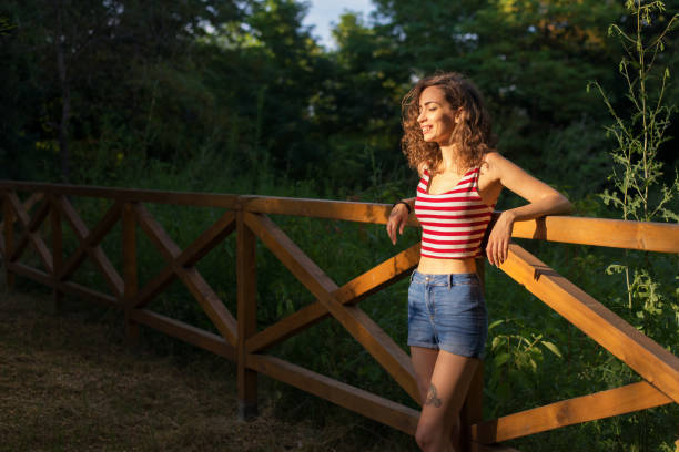 istock Smiling young woman enjoying sunlight in summer nature 1165178932