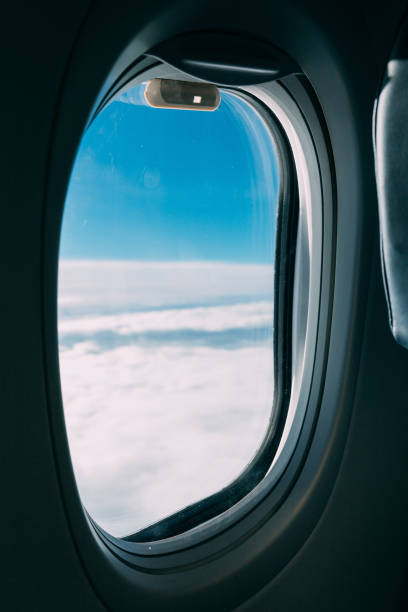 istock airplane window with view of blue cloudy sky 1165180386