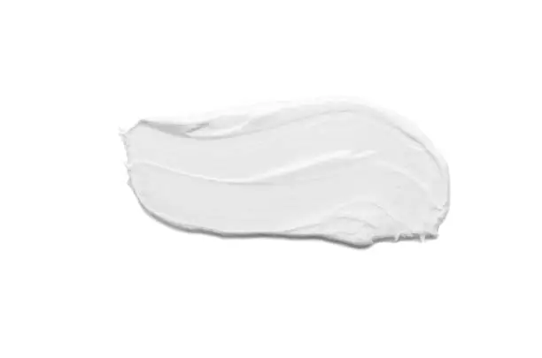 Photo of Moisturizing white face cream smeared isolated on white background.