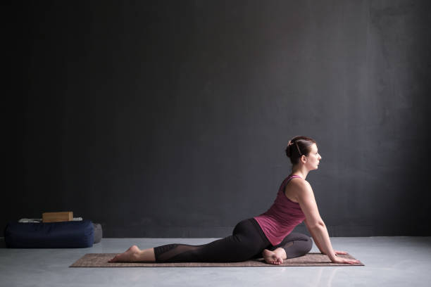 istock woman working out doing easy variation of One Legged King Pigeon Pose 1165181184