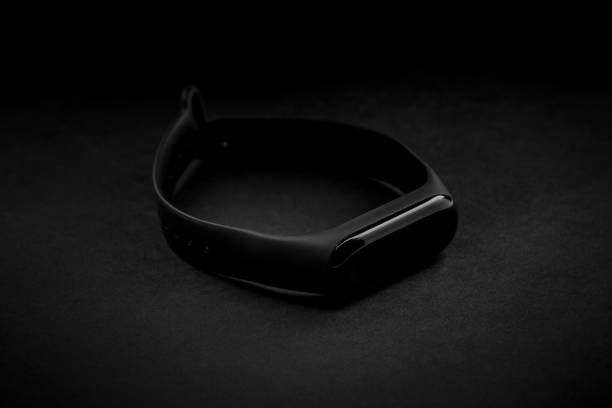 istock black electronic watch and smart fitness tracker at textured black background. dark object at dark background. dark luxury mood. fashionable accessory. 1165182332