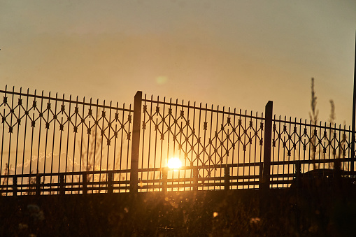 fence against the setting sun. backlit photo
