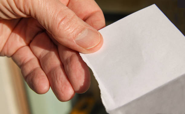 istock Hand holding torn piece of blank paper for copy space. Close up image 1165185530