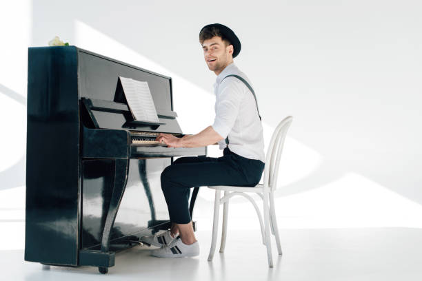 pianista sorridente in abiti alla moda che suonano il pianoforte - piano men pianist musician foto e immagini stock