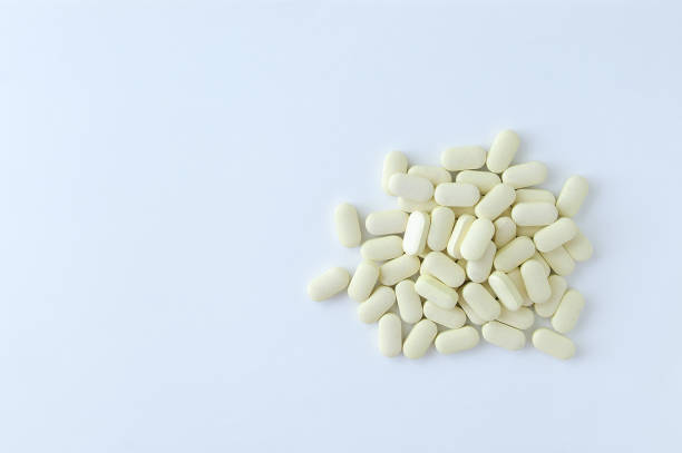 istock Beige pills scatter in a pile. On a white background. View from above 1165186917
