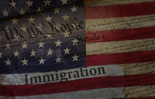 Immigration newspaper headline on US Constitution with American flag