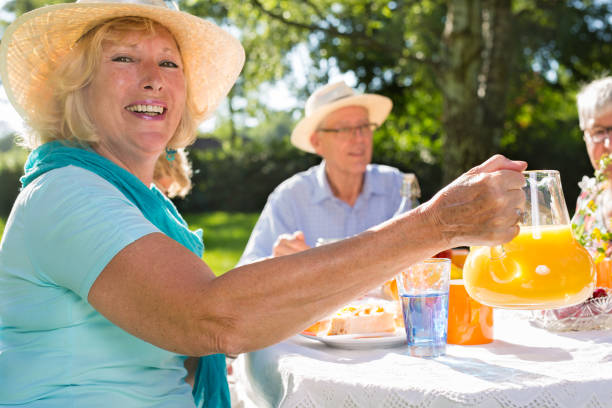 istock Seniors having picnick outdoors in sunshine. 1165188357