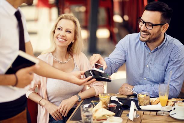 istock Happy couple using smart phone for contactless payment in a restaurant. 1165188645