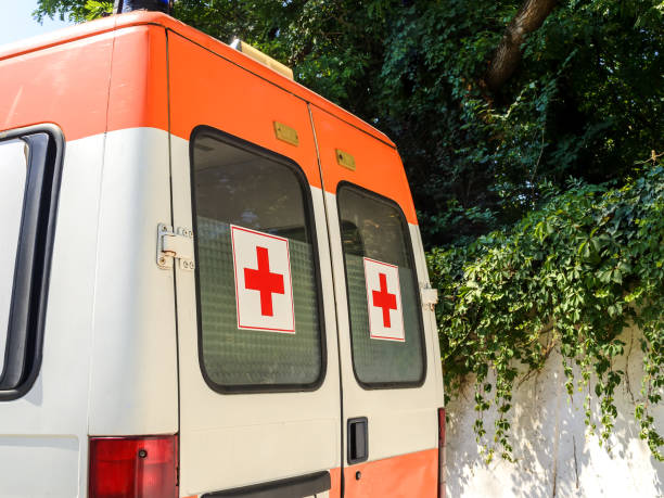 在陽光明媚的夏日,車窗上裝有紅色十字架的固定白色救護車。一輛緊急醫療服務車後視圖。 - 保加利亞 個照片及圖片檔