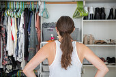 istock Young Woman Deciding What to Wear From Her Closet 1165189815