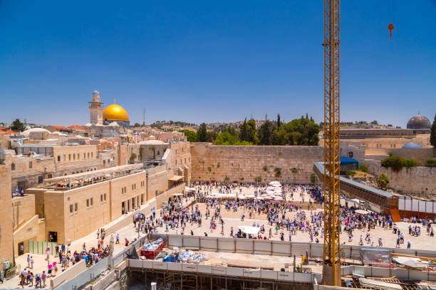 Jerusalem, Israel - June 14, 2018: View from the Temple Mount with the golden Dome of the Rock and people visiting the Western Wall downstairs, the holy site of the Old City in Jerusalem, Israel.