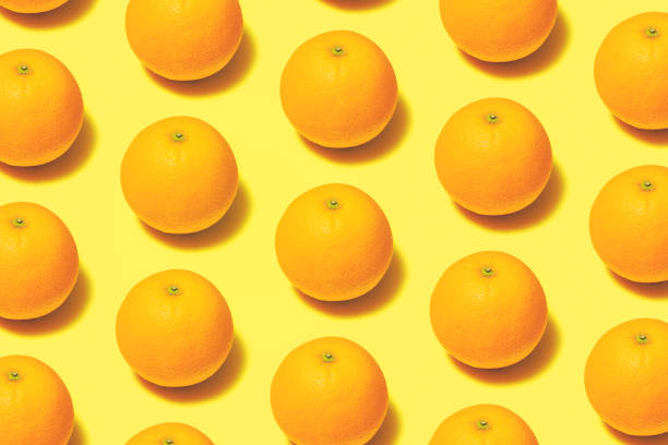 istock Oranges repetitive flat lay on yellow background 1165193576