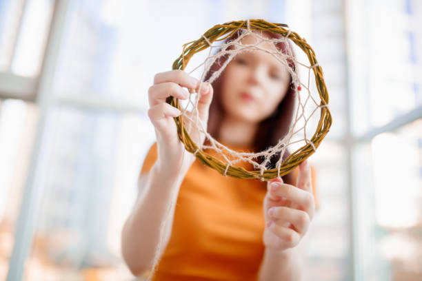 istock Dream catcher creation in art studio. Young woman making decoration accessory for bedroom. Workshop, hobby, handicraft, creativity concept 1165193739