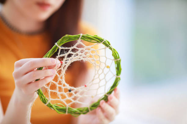 istock Dream catcher creation in art studio. Young woman making decoration accessory for bedroom, closeup photo. Workshop, hobby, handicraft, creativity concept 1165193892