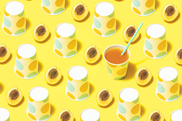 istock Peach juice and polka dot paper cups flat lay on yellow background 1165197670