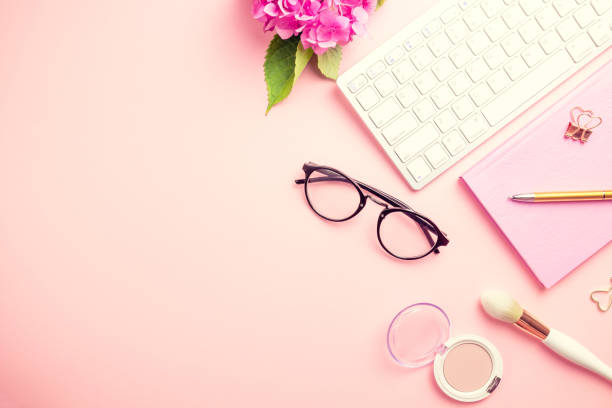 istock Female workspace with laptop, pink hydrangea, golden accessories, pink diary on pink background. 1165201276