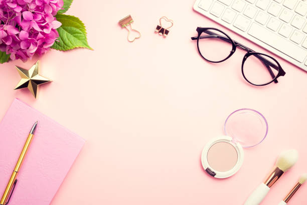 istock Female workspace with laptop, pink hydrangea, golden accessories, pink diary on pink background. 1165201278