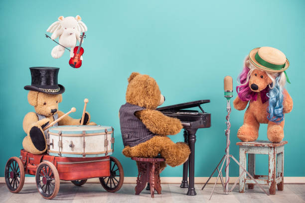 teddy bear toys music band: vocalist with colored hair, retro old microphone, bear in cylinder hat playing drum, flying angel with fiddle, grand piano player. vintage nostalgia style filtered photo - singing singer teenager contest imagens e fotografias de stock