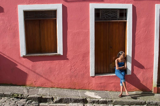 Young woman sitting in the window in the street Salvador Bahia Brazil