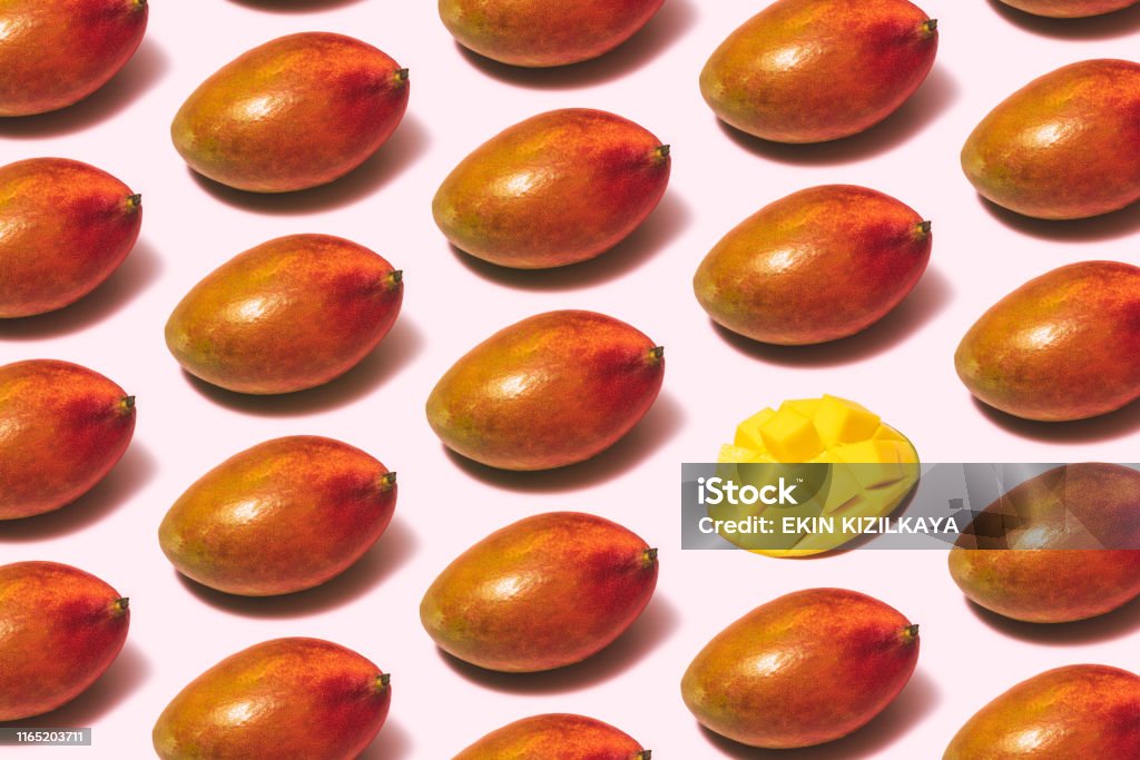 Mango fruit repetitive flat lay on pink background Mango Fruit Stock Photo