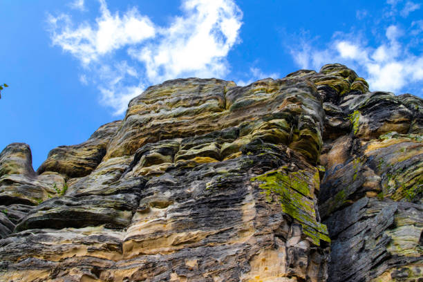 One man, disability young man with prosthetic leg free climbing on a rock in nature..