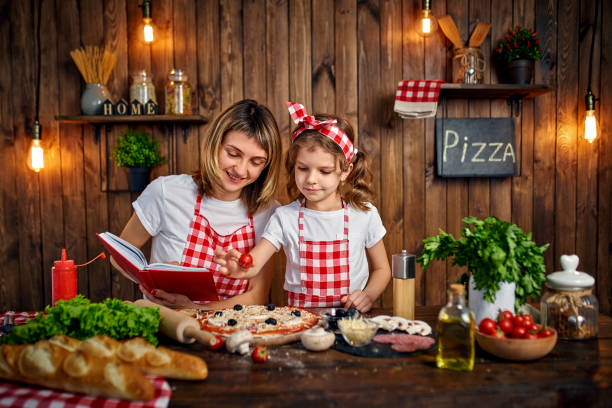 istock Mother teaching daughter cooking pizza 1165206285