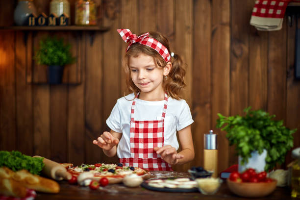 istock Pretty girl in checkered apron cooking pizza 1165206630