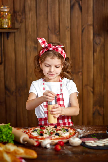 istock Pretty girl in checkered apron cooking pizza 1165206685