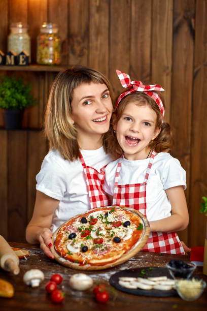 istock Happy Smiling mother and daughter with cooked pizza 1165206721