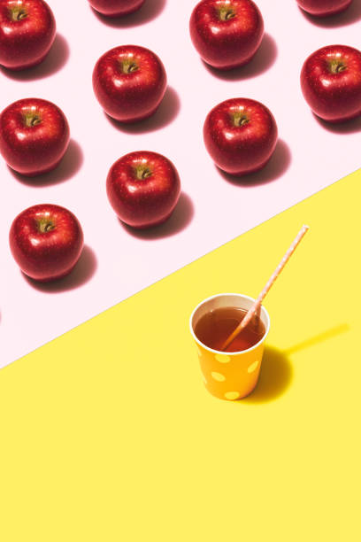 istock Apple juice flat lay on yellow and pink background 1165207875