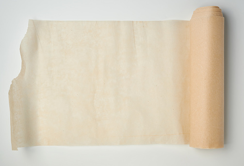 light brown roll with parchment paper spun on a white background, copy space