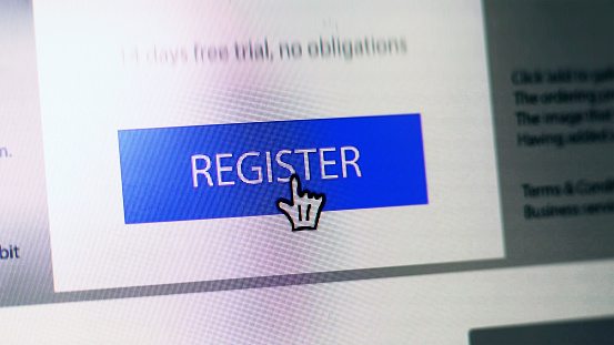 Stock close up image showing a “register” button on a website with hand shaped cursor