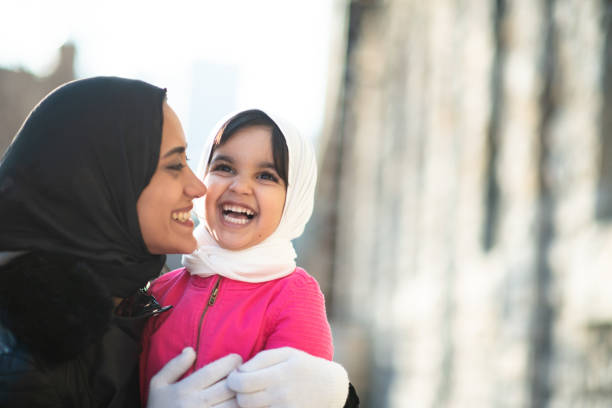 mère et enfant musulmans de sourire - winter migration photos et images de collection