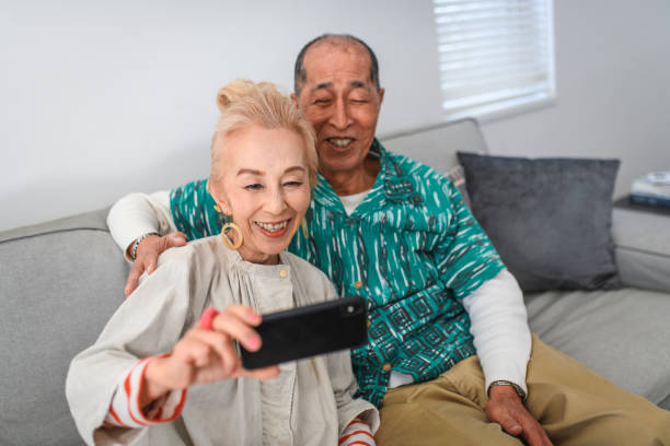 istock Smiling Senior Japanese Woman Creating a Selfie With Husband 1165214832