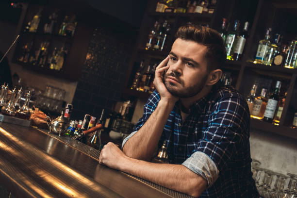 istock Young bartender leaning on bar counter bored close-up 1165215267